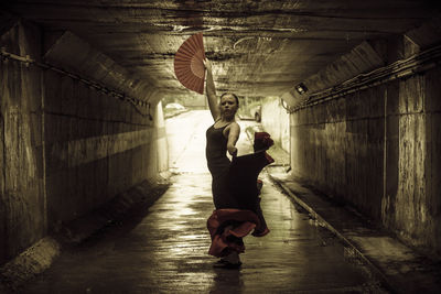 Young woman dancing in tunnel