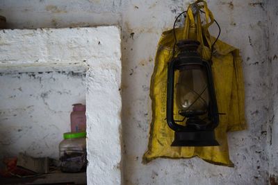 Old-fashioned lantern hanging against wall