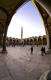 People at historical building against sky