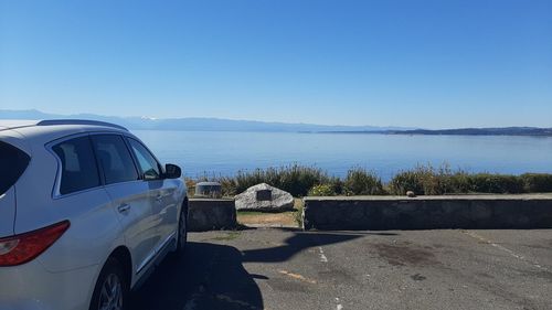 Car on road against clear blue sky