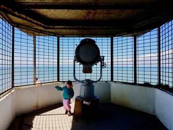 Girl standing in lighthouse on sunny day