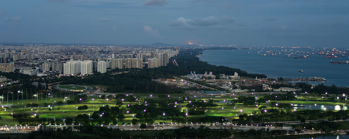 High angle view of city by sea against sky