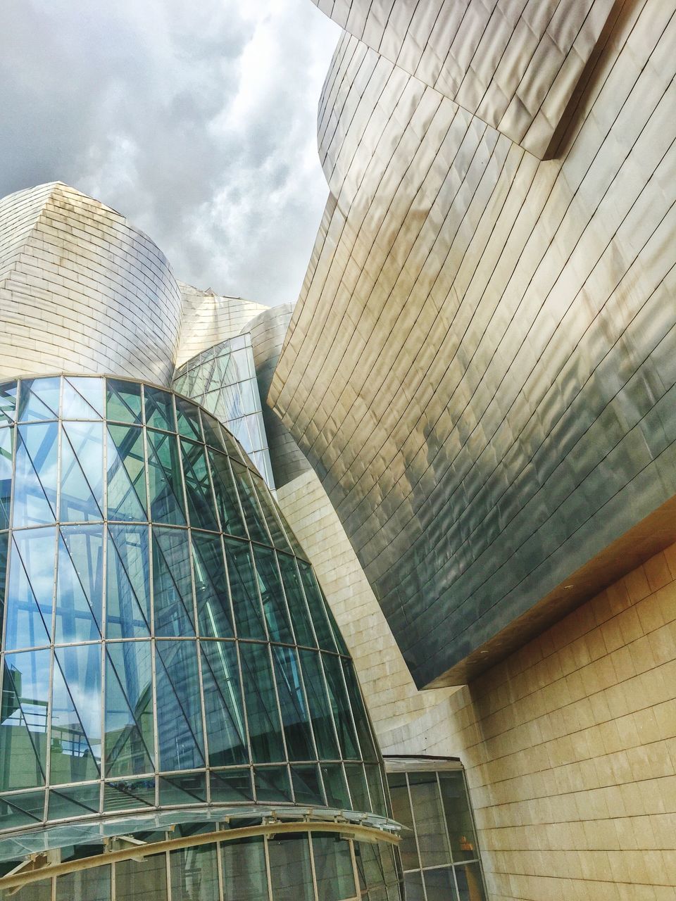 architecture, building exterior, built structure, low angle view, sky, modern, cloud - sky, building, office building, city, cloudy, day, cloud, tall - high, outdoors, no people, architectural feature, exterior, city life, blue, development