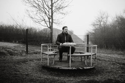 Man sitting on a carousel on a playground 