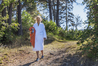 Woman wearing dressing gown holding towel