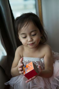 Toddler in ballerina tutu holding a book.