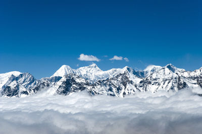 Scenic view of snowcapped mountains against blue sky