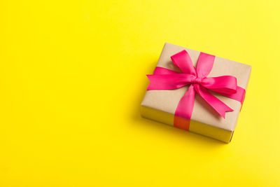 Directly above shot of gift box against yellow background