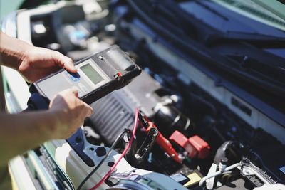 Cropped hands of man repairing car