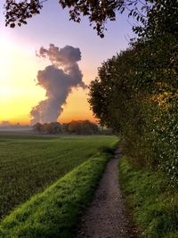 Scenic view of agricultural field against sky during sunset