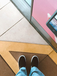 Low section of person standing on tiled floor