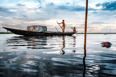 People fishing in sea against sky