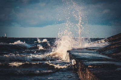 Water splashing in sea against sky