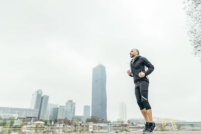 Austria, vienna, jogger training on danube island in front of donau city