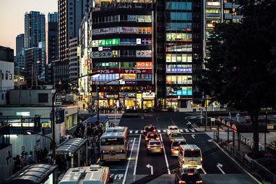 Traffic on city street by buildings at night