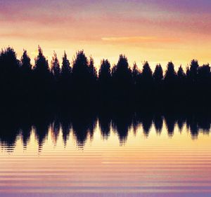 Scenic view of lake against sky at sunset