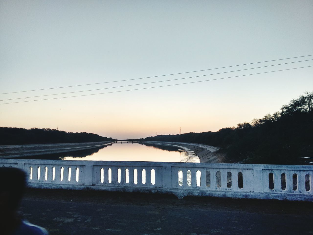 clear sky, water, sunset, transportation, river, copy space, reflection, nature, built structure, bridge - man made structure, bird, outdoors, sky, lake, silhouette, connection, tranquil scene, tranquility, railing, architecture