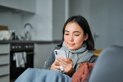 Portrait of young woman sitting at home