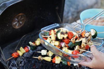 Midsection of person preparing food on barbecue grill