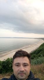 Portrait of young man in sea against sky