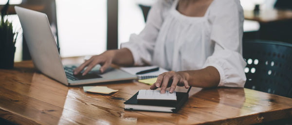 Midsection of man using laptop on table