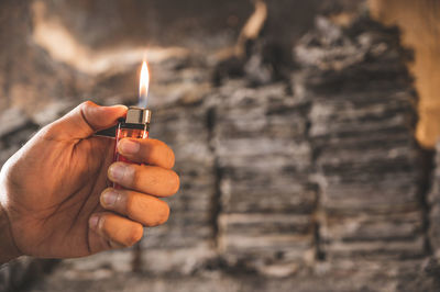 Close-up of hand holding burning candle