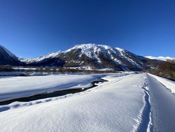 Scenic view of snowcapped mountains against clear blue sky