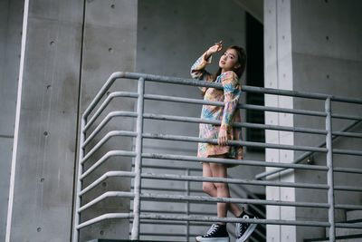 Low angle view of young woman standing on escalator