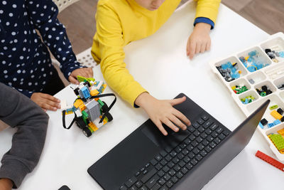 Kids learning coding, science and technology at school class. african american and caucasian