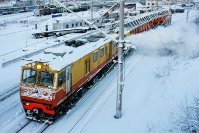 High angle view of locomotive on snowcapped railroad track during winter