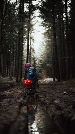 Side view of girl standing on field in forest