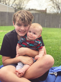 Portrait of boy sitting on field
