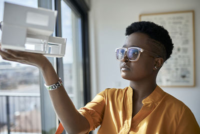 Female architect looking at architectural model in office