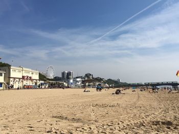 Panoramic view of people on beach against sky