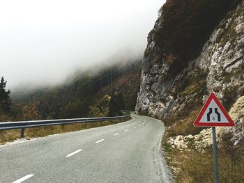 Road signs on mountain against sky