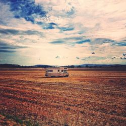 Scenic view of field against cloudy sky
