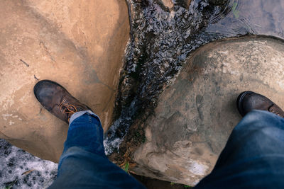 Low section of man walking on rock