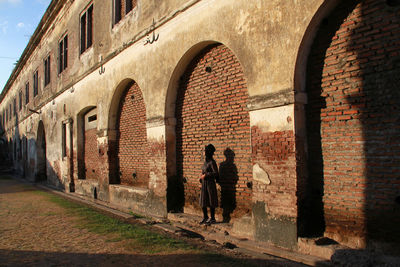 Full length rear view of man walking in old building