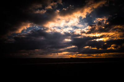 Scenic view of storm clouds over silhouette landscape