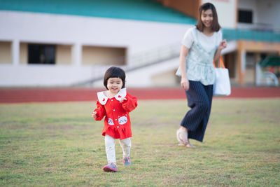 Full length of mother and daughter standing outdoors