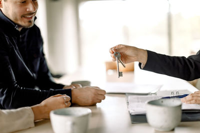 Real estate agent giving key to couple at home