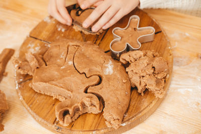 Children's hands carve cookies on gingerbread dough from figurines. girl preparing christmas cookies