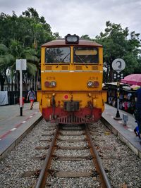 Yellow train on railroad track against sky