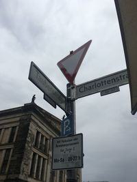 Low angle view of road sign against sky