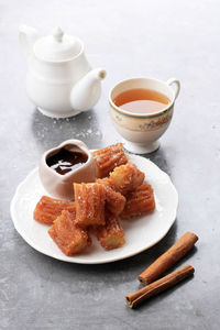 Churros with cinnamon sugar and chocolate sauce, served with tea