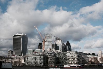 Buildings in city against cloudy sky