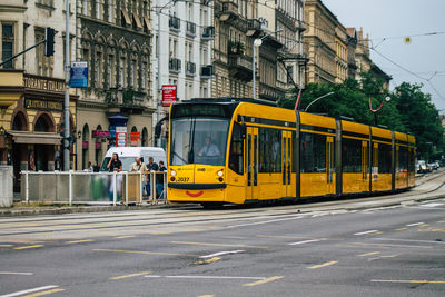 Yellow train on city street