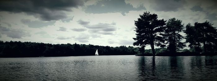 Scenic view of river against cloudy sky