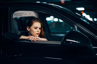 Portrait of young woman sitting in car