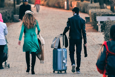 Rear view of people walking on footpath